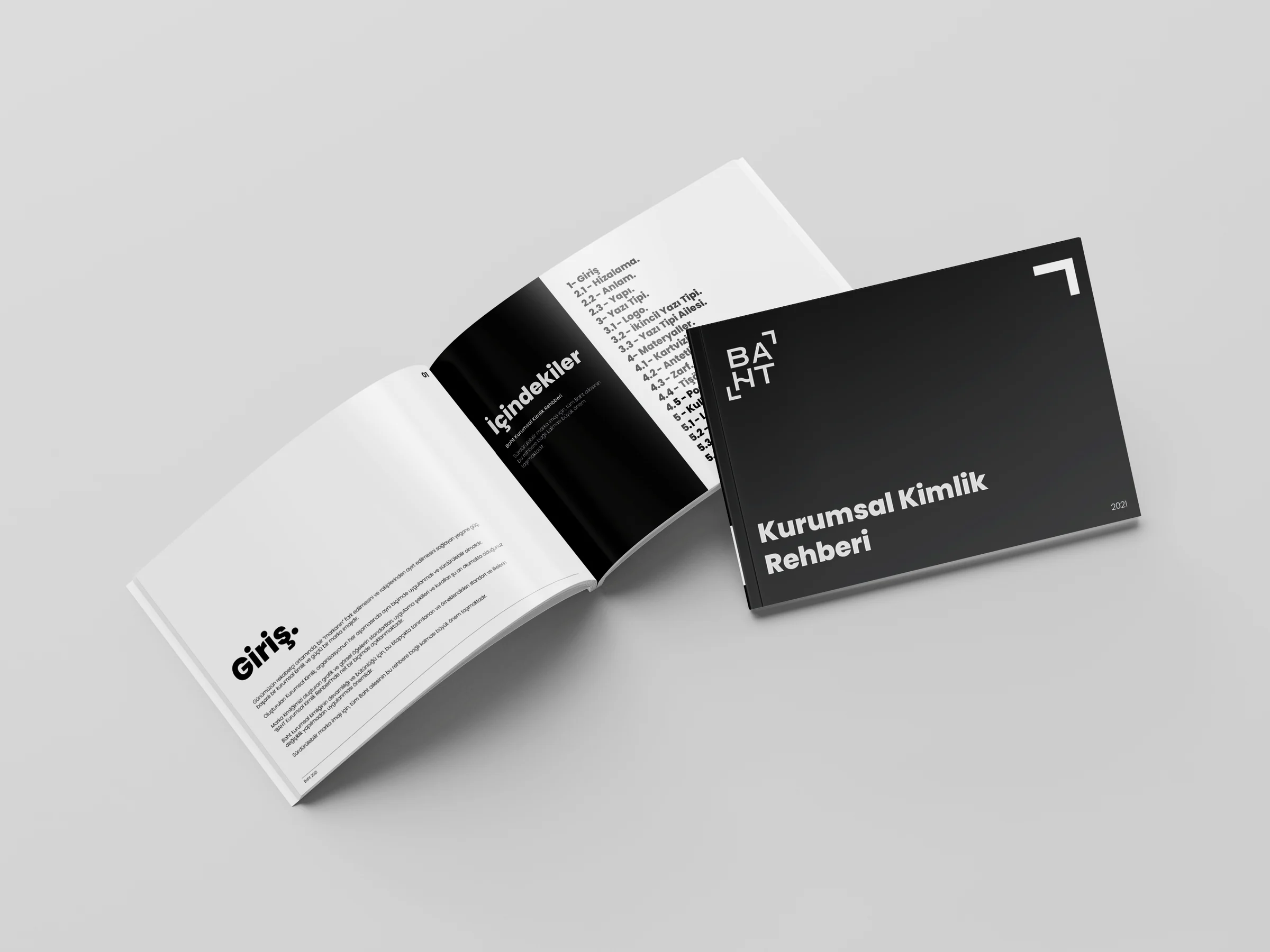 Two baht identity guides: one open at the introduction and contents, one closed on the black cover titled Kurumsal Kimlik Rehberi.