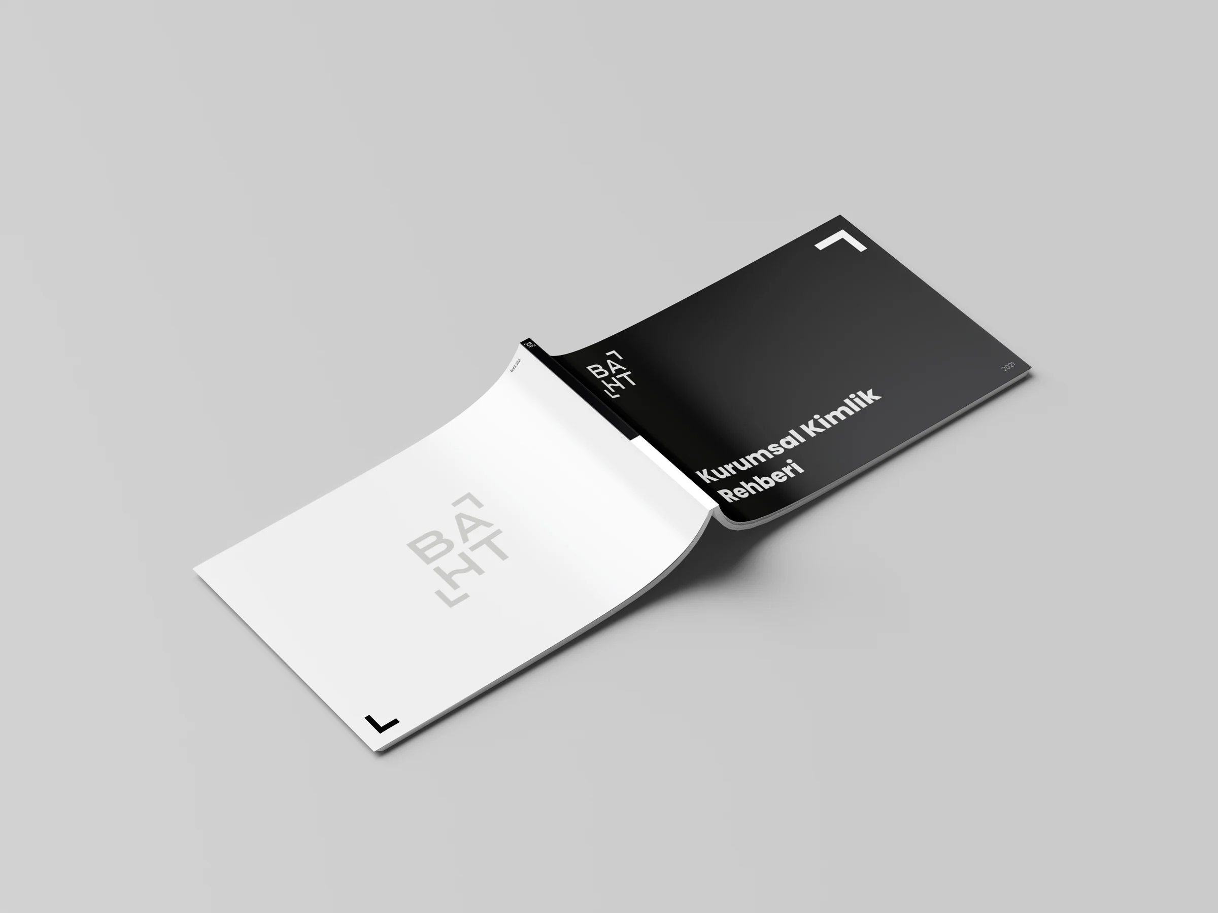 Front and back covers of the baht identity guide laid flat: black front with the title, white back with a light grey logo.