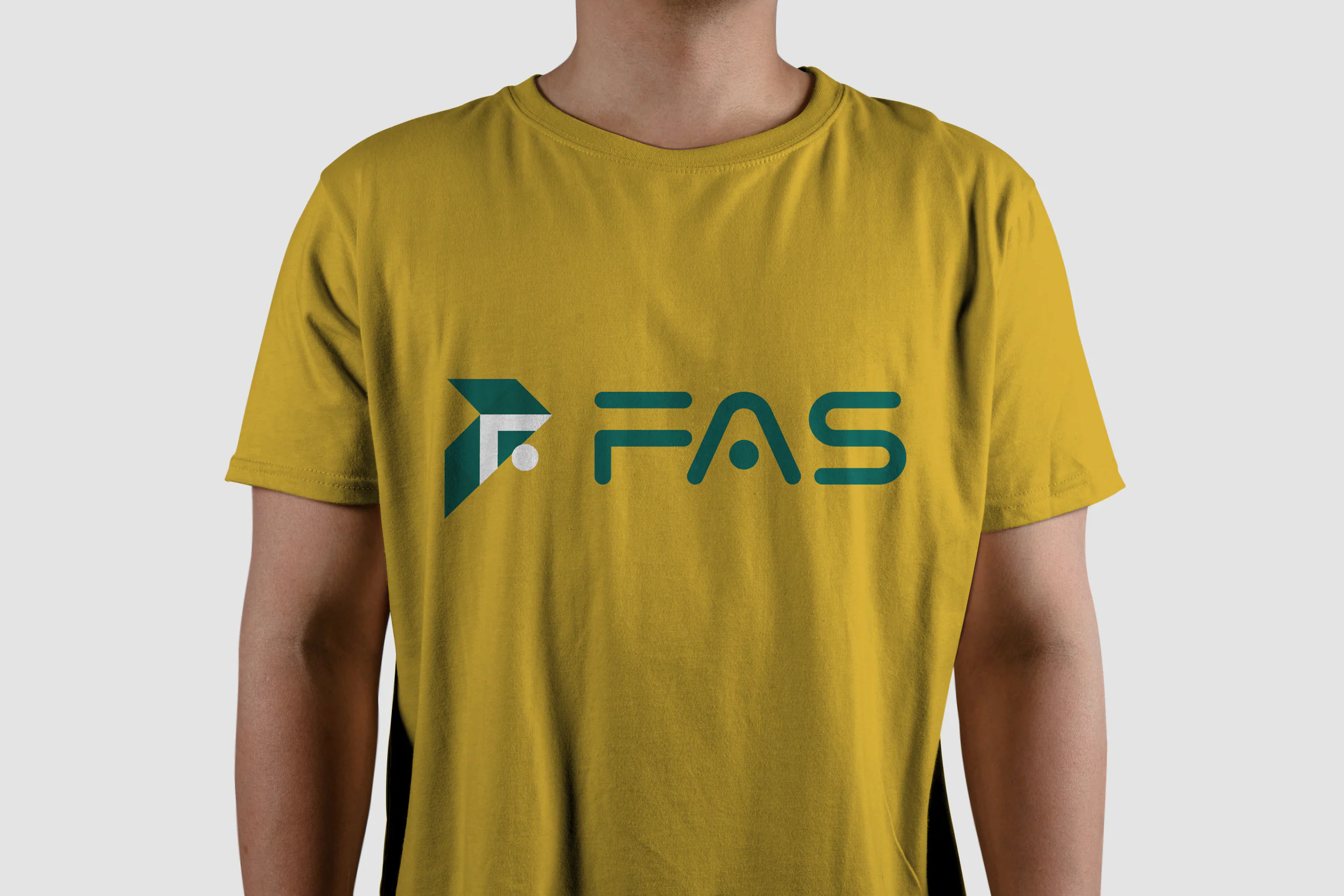 Mustard yellow T-shirt on a model's torso, printed with the green FAS logo mark and wordmark.