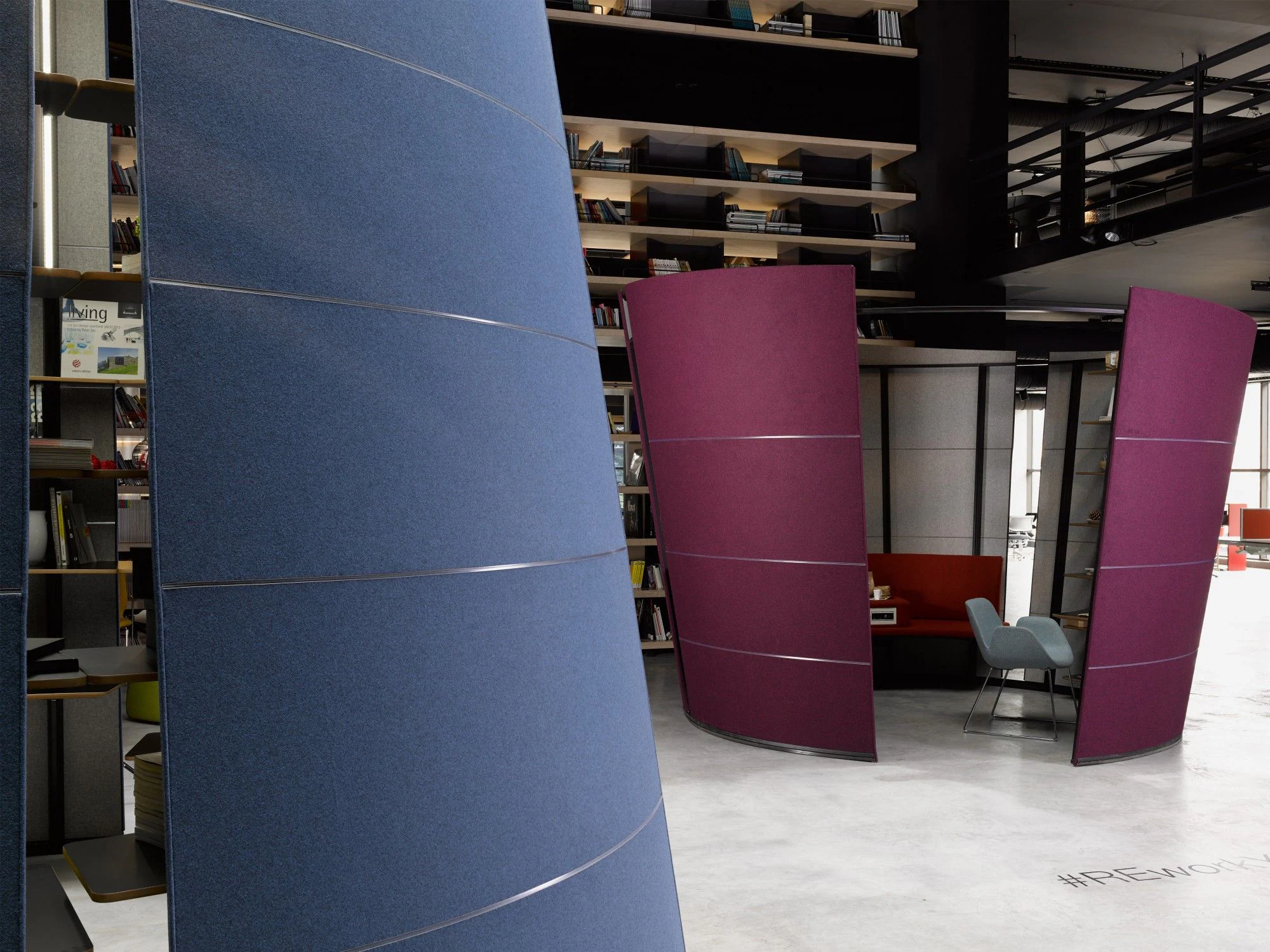 Original Oblivion panels: a blue panel in front, two plum panels around a red sofa booth with a grey chair, bookshelves behind.