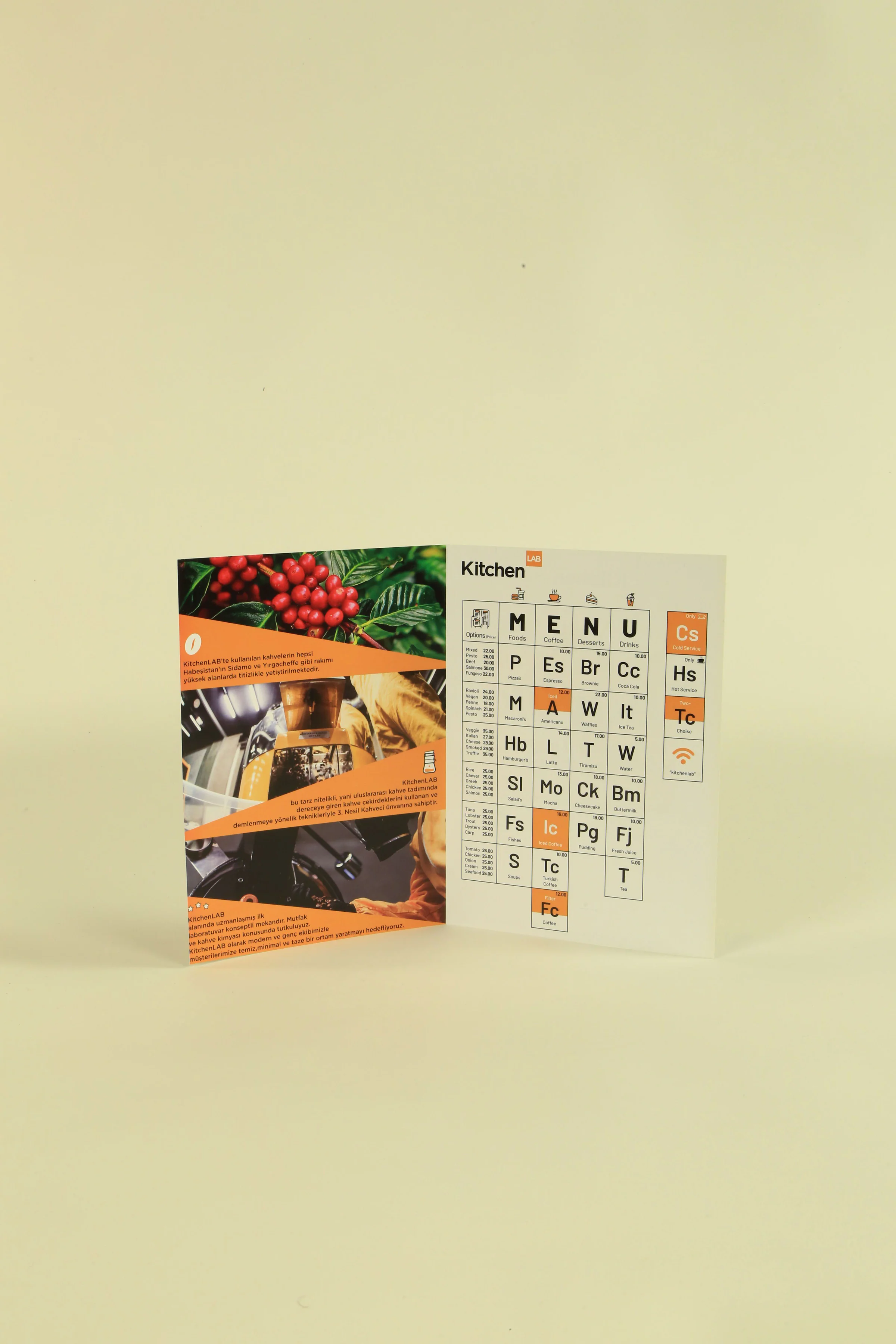 Open brochure: coffee cherry and roasting photos with Turkish text on orange bands at left, the periodic-table menu at right.
